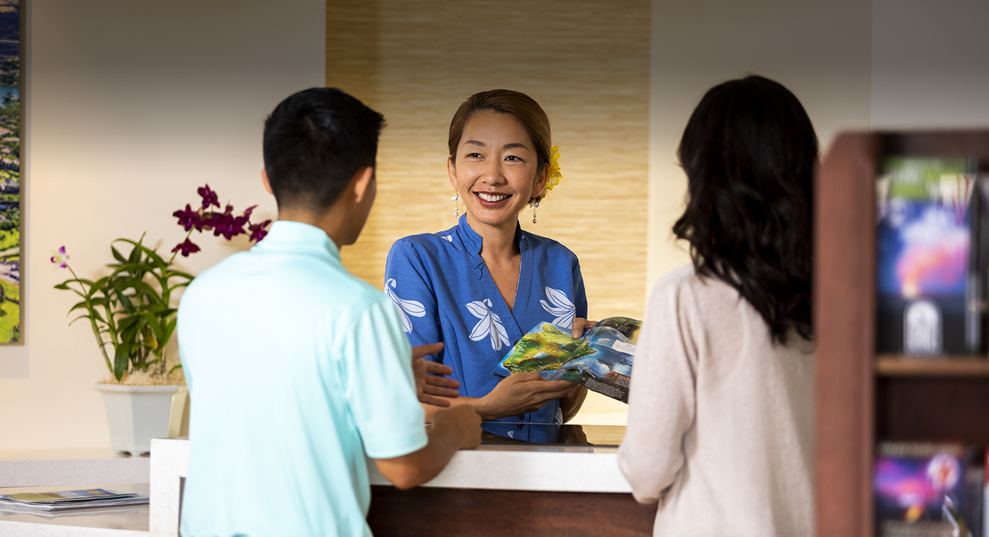 Japanese team member showing brochure to guests